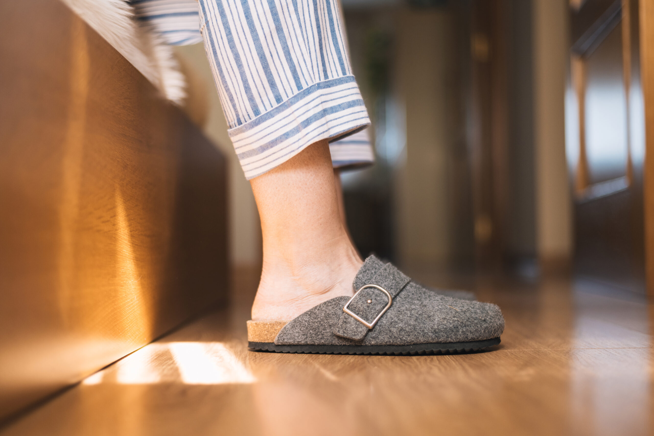 Person wearing comfortable pajamas and warm felt slippers getting out of bed in the morning, enjoying a peaceful daily routine and cozy home lifestyle